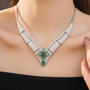 Detail view of vintage court style necklace with emerald green stones and pavé crystals
