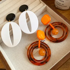 Close-up of vintage resin drop earrings in warm Maillard tones on a velvet tray.