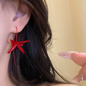 Elegant red metallic flower drop earrings with minimalist retro design worn on ear