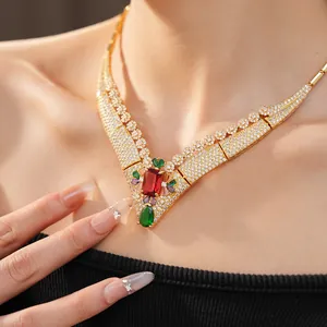 Close-up of vintage royal style gold necklace with red square and green teardrop zircon stones