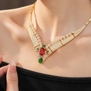 Close-up of 18k gold plated vintage zircon necklace with red and green gemstones on model