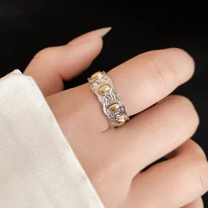Detalle de un anillo ajustable bicolor minimalista con diseño ovalado para mujer