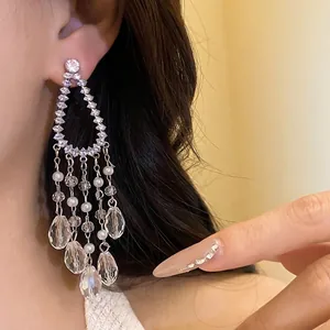 Elegant silver needle cubic zirconia tassel earrings with pearls shown on model ear