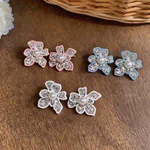 Elegant hollow flower stud earrings with pearl centers in pink blue and white colors