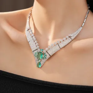Close-up of vintage emerald green zircon necklace on neck showing luxury detail.
