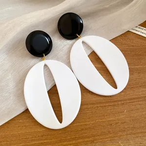 Detailed shot of black and white resin oval drop earrings with minimalist retro design