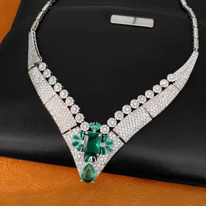 Close-up view of a vintage court-style necklace with emerald stones and paved zircons