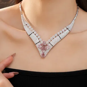 Close-up of a vintage court style V-shaped necklace with pink zircons and white stones