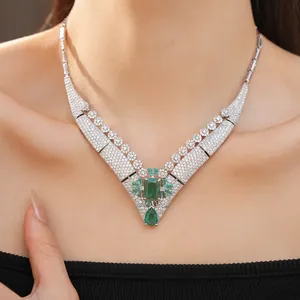 Close-up view of a vintage court style necklace with green zirconia stones on a model.