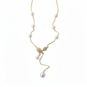 Elegante collana a Y placcata in oro 18 carati con foglie di zircone e perle su fondo bianco.