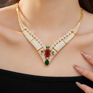 Detail showing the 18k gold plated zirconia necklace with red and green gemstones.