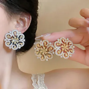 Close-up of teardrop flower earrings with yellow zircons and 18K gold plating