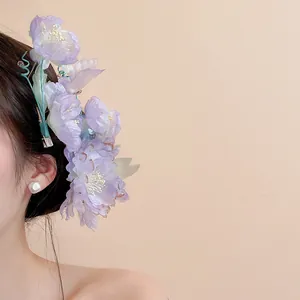 Close-up of a delicate purple fabric flower hair clip worn as a stylish side accessory.