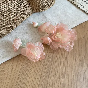 Macro detail of elegant pink fabric flower hair clips with delicate pearl stamens