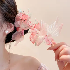 Detailed view of pink silk fabric flower hair clips with pearls on an Asian model
