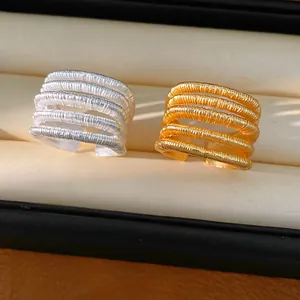 Macro view of gold and silver multi-layer coiled open rings displayed in a jewelry box