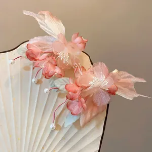 Close-up of elegant pink fabric flower hair clips featuring delicate pearl tassels