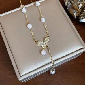Dettaglio di collana a foglia placcata oro 18k con perle e pavé di zirconi cubici