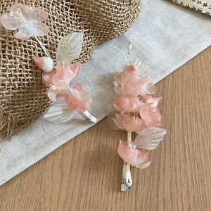 Detailed view of ethereal pink fabric flower hair clips with elegant pearl accents