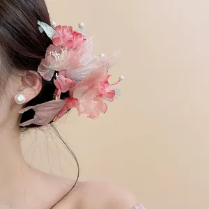 Detailed close-up of a pink fabric floral hair clip with elegant pearl accents for Hanfu