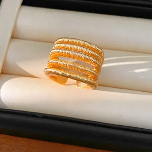 Macro detail of an 18k gold plated multi-layer textured open ring in a jewelry box