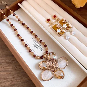Primo piano di collana di fiori di perline vintage e orecchini abbinati in una scatola
