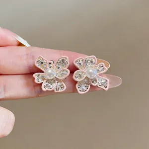 Close-up detail of elegant pink enamel hollow flower stud earrings featuring white pearl centers