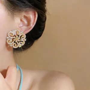 Detailed macro shot of an 18K gold plated zircon water drop flower earring worn.