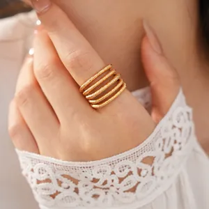 Detailed close-up shot of an elegant 18k gold plated multi-layer spiral ring on a finger