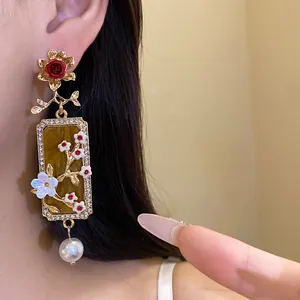 Primo piano di orecchini a fiore stile palazzo vintage con perla e dettagli floreali