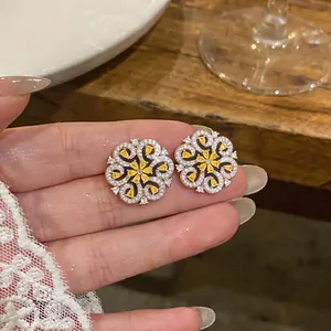 Exquisite French vintage flower stud earrings with yellow zircons held in hand