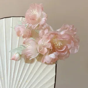 Detailed macro view of a delicate pink fabric flower hair clip for Hanfu styling.