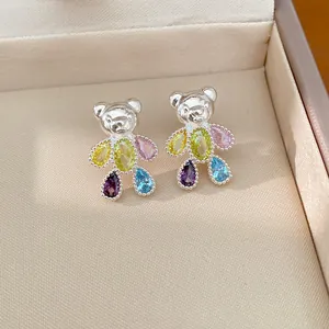 Macro view of exquisite silver bear stud earrings with vibrant multi-color zircon stones