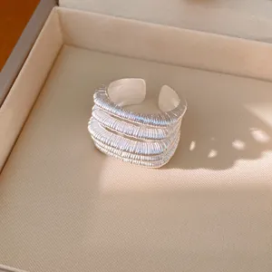 Detailed close-up of a minimalist silver multi-layer open ring with brushed texture