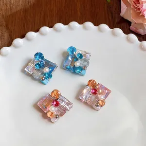 Elegantes pendientes de plata cuadrados con cristales de colores y perlas blancas de diseño.
