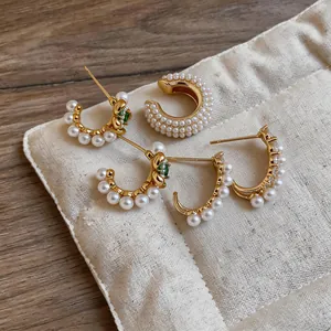 Eleganti orecchini di perle placcati in oro 18 carati con pietre verdi su tessuto