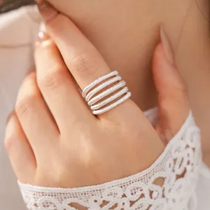 Detailed shot of a textured multi-layer silver open ring on index finger with lace