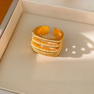 Close-up detail of 18k gold-plated multi-layer hollow open ring with textured finish