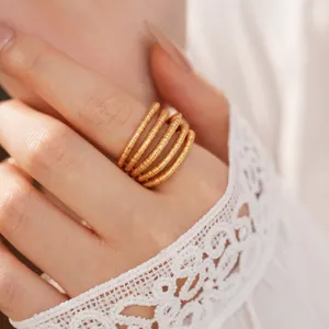 Detailed macro view of 18k gold plated multi-layer coiled ring worn with lace sleeve