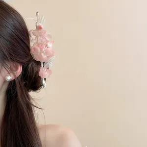 Detailed macro view of a pink fabric flower hair clip with pearl accents styled on hair
