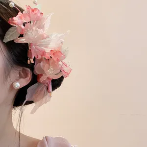Detail view of a pink fabric flower hair clip with delicate pearl accents