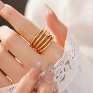 Elegant macro view of an 18k gold plated multi-layer hollow open ring on a finger.