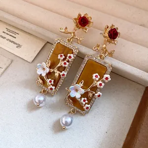 Vista dettagliata di orecchini vintage in stile palazzo con ambra e perle