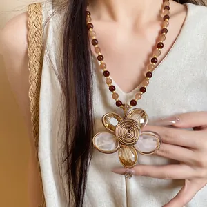 Primo piano di una collana di perle vintage con un grande ciondolo a forma di fiore