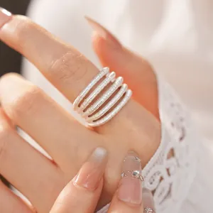 Close-up detail of a minimalist multi-layered silver open ring with textured finish.