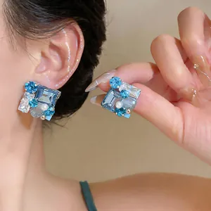 Primer plano detallado de pendientes de cristal azul con elegantes detalles de perlas