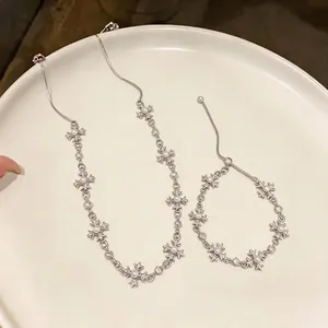 Elegant cross fleur-de-lis pearl necklace and bracelet jewelry set on white tray