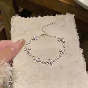 Elegant silver-toned bracelet with fleur-de-lis cross charms, pearls and crystals for women