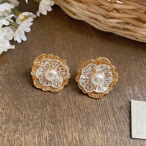 Close-up of elegant French vintage pearl floral stud earrings with hollow petal design.