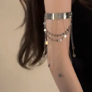 Primo piano del bracciale da braccio argento con nappine a catena e paillettes